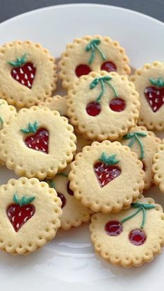 small cookies decorated with cherries on a white plate