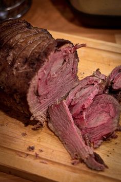 a large piece of meat sitting on top of a wooden cutting board