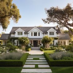 a large white house surrounded by trees and bushes