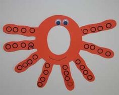 an orange paper cut out with circles on it's face and eyes in the shape of a octopus