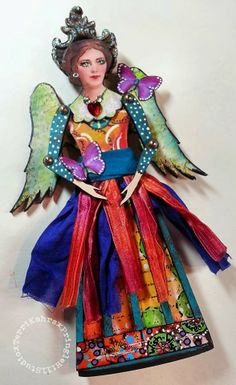 an angel doll is wearing a colorful dress and tiara