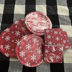 red and white paper plates with snowflakes on them sitting on a black and white checkered tablecloth