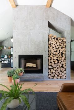 a living room filled with furniture and a fire place covered in lots of wooden logs