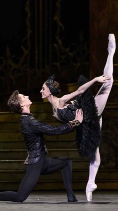 two ballerinas in black outfits are performing on stage