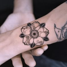 a woman's arm with a tattoo on it that has a large flower in the middle