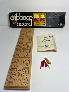 a wooden board game with pieces and instructions on the back side, including two cribbag boards