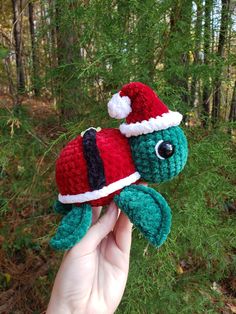 someone is holding up a crocheted christmas turtle