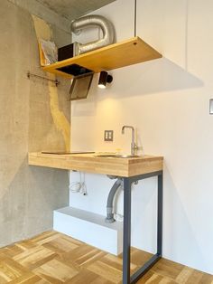 a kitchen with a sink and wooden flooring next to a wall mounted heater