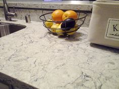 a bowl filled with fruit sitting on top of a kitchen counter