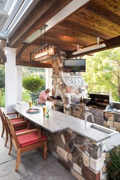 an outdoor kitchen with stone counter tops and grill