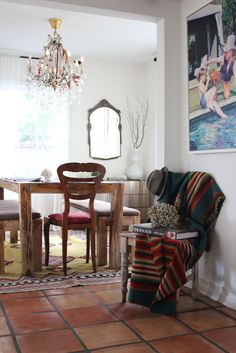 a dining room table and chairs with a chandelier hanging from the ceiling above it