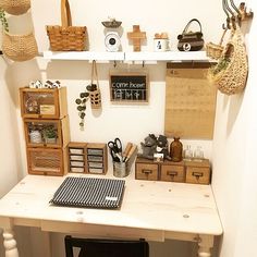 a white desk topped with lots of wooden boxes and baskets next to a wall mounted shelf