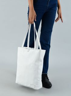 Step out in style and confidence with this iconic white leather shoulder tote bag, a classic embodiment of grace and functionality. Handcrafted by skilled artisans, it radiates timeless craftsmanship. Crafted from full-grain buffalo soft leather, it blends durability with an enduring charm. The secure zipper closure safeguards your essentials, while a thoughtfully designed inside pocket organizes coins, keys, purse, or your phone. Ideal for office use, it accommodates tablets or small laptops wi Minimalist White Bag For Travel, Minimalist White Travel Bag, White Satchel With Smooth Grain, White Shoulder Bag With Leather Handles For On-the-go, Minimalist White Bag For Everyday Use, White Leather Shoulder Bag With Leather Handles, White Leather Shoulder Bag For Everyday Use, White Textured Leather Travel Bags, White Minimalist Shoulder Bag For Daily Use