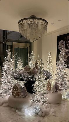 christmas trees are in the middle of a room with chandeliers and lights on them