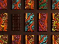 chocolate bars with colorful designs on them are lined up against a brown wall and placed next to each other