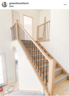 a staircase with blue tape on the bottom and handrails in an empty room