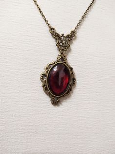 ◆ Victorian style necklace. The red blood cabochon size is 0.984252 x 0.708661 inches and it was completely handmade in resin. The inserts, the base and the chain are in bronze, The product is made by hand with great care. ♡ In my shop there are many handmade jewelry for all tastes, come and watch them are welcome! ♡ Red Amulet Necklace, Red Vintage Jewelry, Red Gem Jewelry, Antique Garnet Pendant Necklace, Vintage Ruby Necklace For Formal Occasions, Victorian Ruby Necklace For Formal Occasions, Antique Red Garnet Necklace, Vintage Red Garnet Necklace, Victorian Style Brass Necklace With Oval Pendant