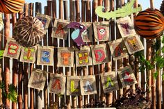 a wooden fence decorated with paper cut out animals and letters hanging from it's sides