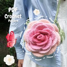 a crocheted pink flower is held in front of a woman's face