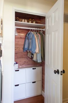 an open closet with clothes and shoes on hangers