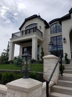 a house with stairs leading up to it and a lantern in the front yard area