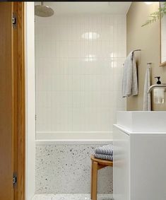 a bathroom with a sink, toilet and bathtub next to a wooden door in it