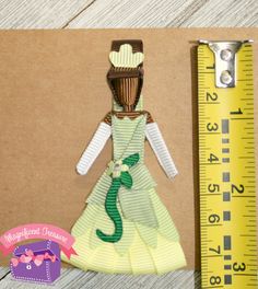 a paper doll is next to a ruler