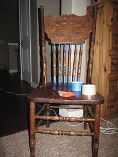 an old wooden rocking chair with blue cups on it's seat in front of a dresser