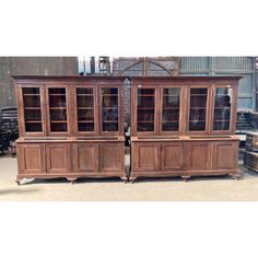 two wooden bookcases sitting next to each other on top of a table in a warehouse