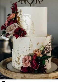 a three tiered wedding cake with flowers on top