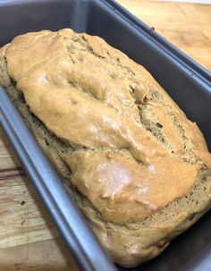 a loaf of bread sitting in a pan on top of a wooden table