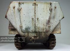 an old dirty truck is sitting on the floor in front of a white wall and grey background