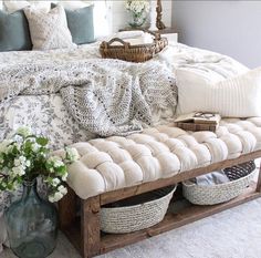 a bed with pillows, blankets and baskets on it