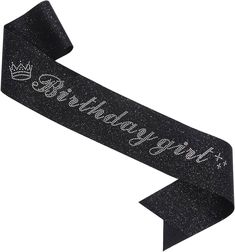 a black ribbon with the words happy birthday written on it and a crown in silver glitter