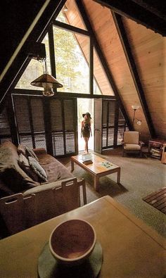 there is a woman standing in the living room looking at something on the coffee table