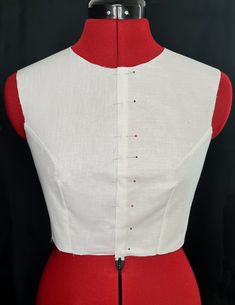 a red and white dress on a mannequin's torso, with the bottom part cut off