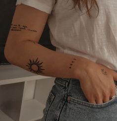 a woman with a sun and moon tattoo on her arm