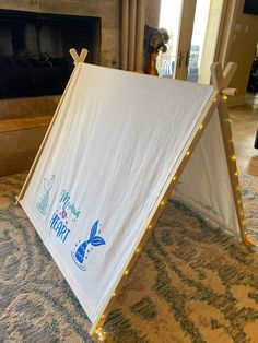 a white tent sitting on top of a carpeted floor next to a fire place