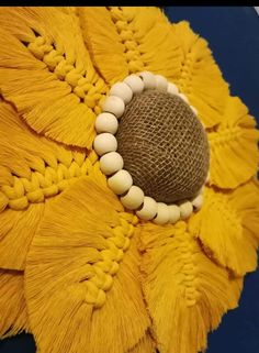 a yellow flower with white beads and tassels