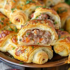 several sausage rolls on a plate with some garnish