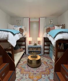 two bunk beds in a small room with a rug on the floor