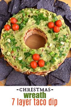 a christmas wreath made out of tortilla chips and topped with avocado