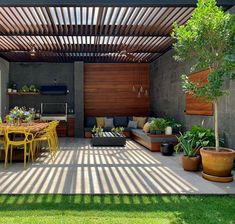 an outdoor living area with patio furniture and potted plants on the table, surrounded by wooden slatted walls