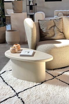 a living room filled with lots of furniture and decor on top of a white rug