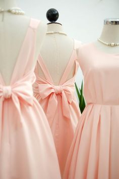 three bridesmaid dresses on mannequins with bows