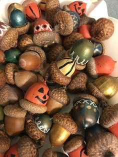 a bowl filled with lots of different colored acorns