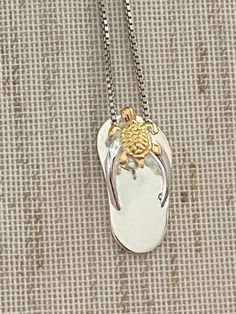 ".925 Sterling Silver w/ 14K Yellow Gold Hawaiian Turtle Honu Slipper Flip-Flop Necklace. The length is 20MM, about 3/4\". The highly-detailed Honu is 6.5MM. FREE Italian Sterling Silver Box Chain Included in your choice of length. The Highly-reflective Sterling Silver finish is stunning, durable & will shine for years to come. This popular design is super adorable in person. --The Hawaiian Turtle is the only indigenous reptile in the Islands. Symbols of the Turtle are often exchanged to sig Adjustable Engraved Necklaces For Beach, Engraved Gold Beach Jewelry, Gold Sterling Silver Jewelry For Beach, Adjustable Engraved Necklaces For The Beach, Gold Sterling Silver Necklace For Beach, Sterling Silver Pendant Jewelry For Beach, Engraved Pendant Necklace For Beach, Beach Pendant Jewelry With Engraving, Beach Engraved Pendant Jewelry