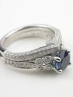 an antique style engagement ring set with blue sapphire stone and diamond accents in white gold