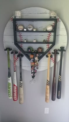 a baseball bat and some baseballs hanging from a rack on the wall in a room