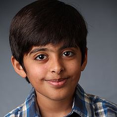 a young boy is posing for a photo with his eyes wide open and looking at the camera